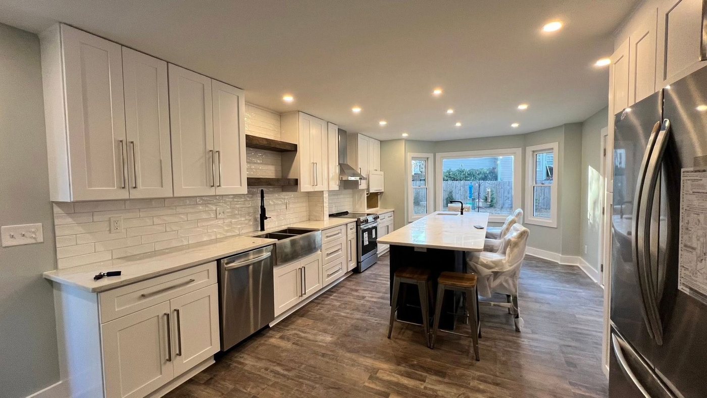 The same bay windows — now an open white kitchen with a full island