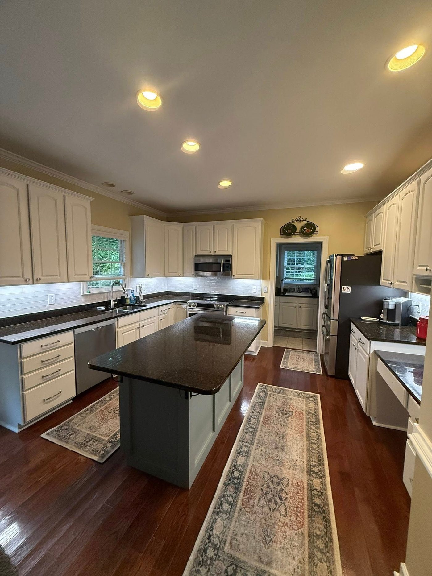The finished kitchen: white cabinets, dark counters, gray island