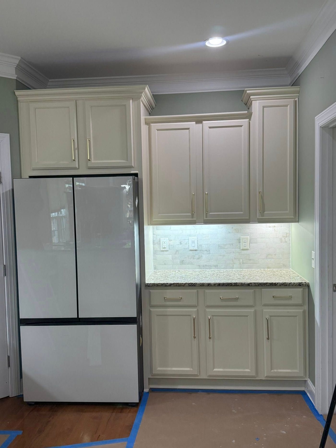 The same corner after: light gray cabinetry and new backsplash