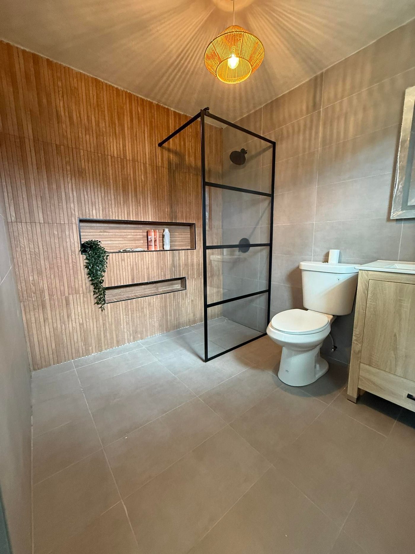 Bathroom with black-frame glass shower and slat wall