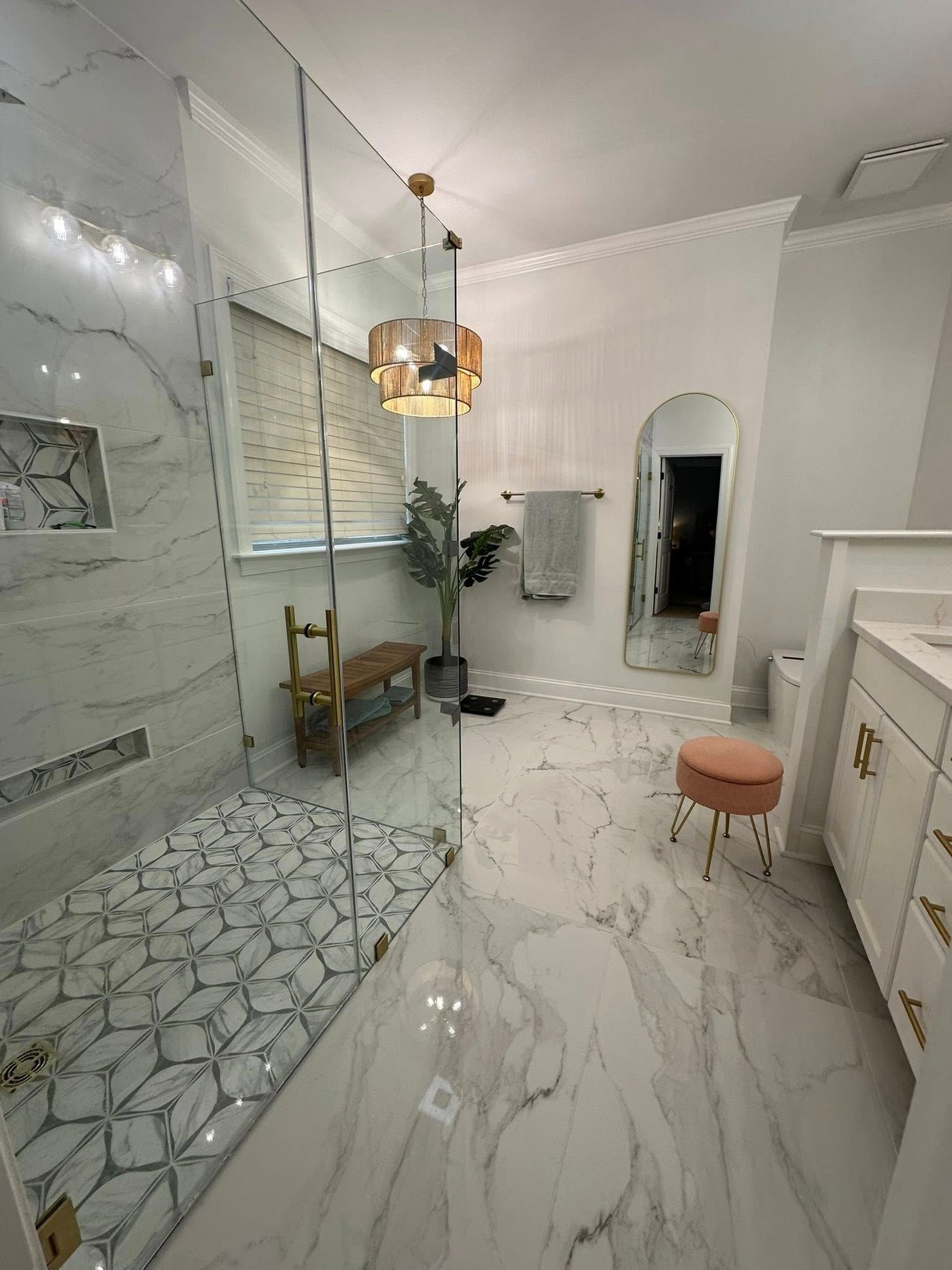 Marble bathroom with gold fixtures and arched niche
