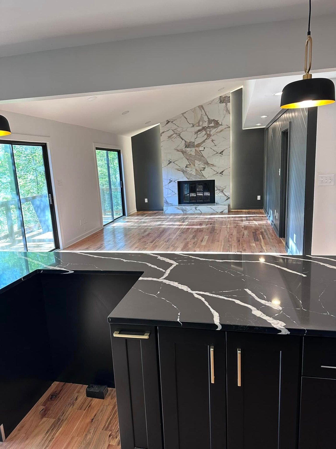 Black quartz counter and marble fireplace wall