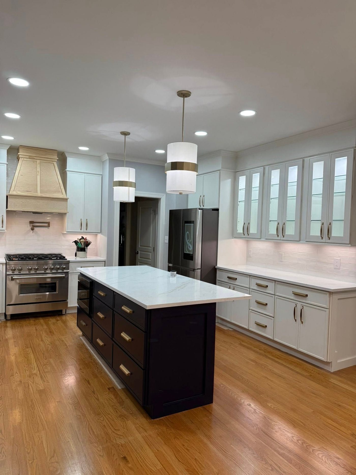 Kitchen with glass-front uppers and dark island