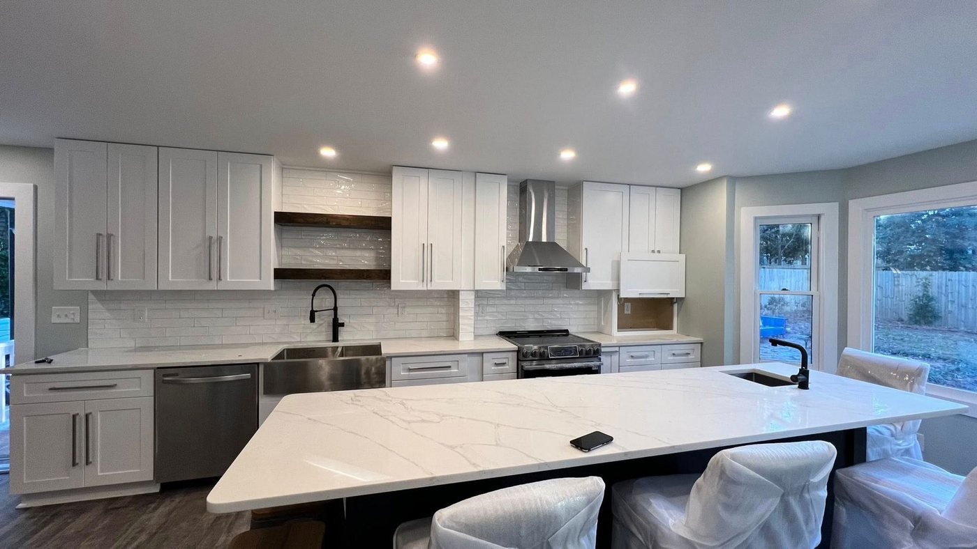 White kitchen with marble island and farmhouse sink