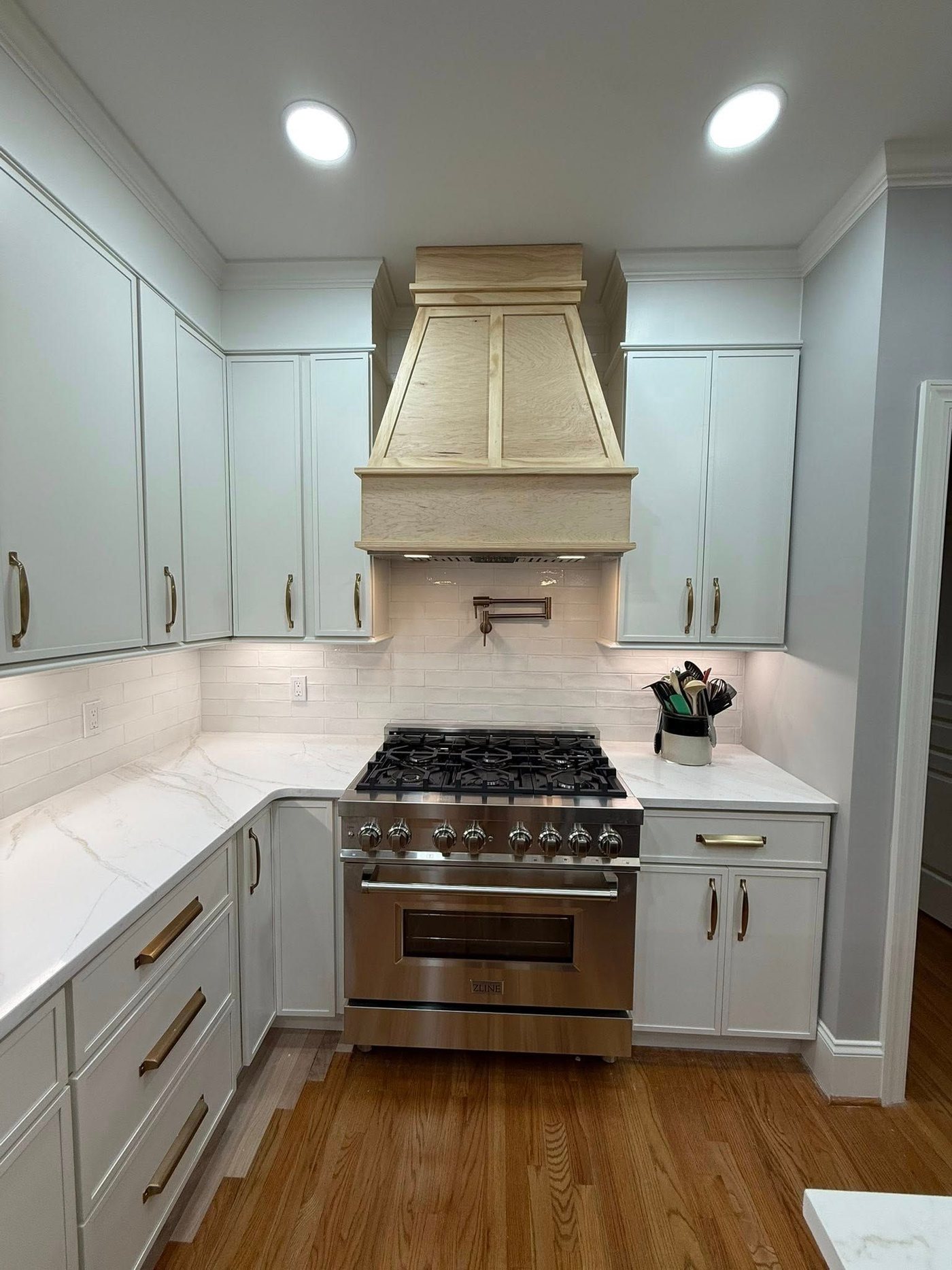 Kitchen with custom wood hood and professional range